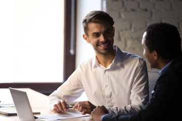 Diverse employees working together, discussing project, business strategy