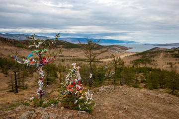 A sacred place of power with ribbons at Lake Baikal on a hill. Traditions of Buryatia in Russia....