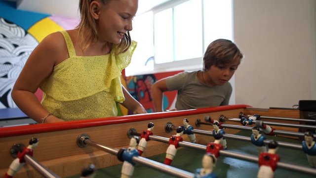Family on vacation playing foosball