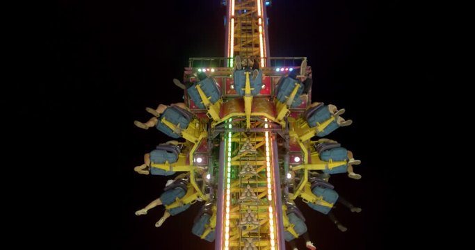 People plunging from the sky in a tower drop carnival ride