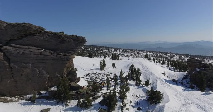 Aerial -  Climber conquers the rock. girl climbs up the rock. Climber climbs on the outlier of a rock in a beautiful valley. aero shooting in motion. dynamic shot