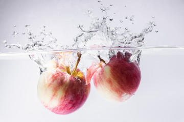 Water splashing with red apple on white background. fresh, healthy concept