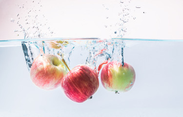 Water splashing with red apple on white background. fresh, healthy concept