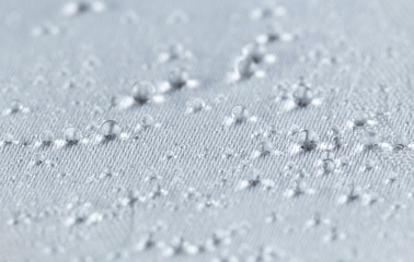 Water drops on white waterproof fabric. Horizontal image.