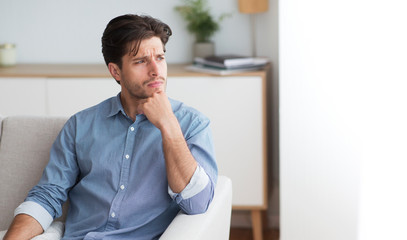 Guy Thinking Looking Aside Sitting On Couch At Home