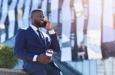 Business Man Talking On Cellphone Holding Coffee Cup Sitting Outdoor