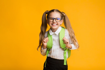 Happy Schoolgirl Smiling Posing At Camera, Yellow Background, Studio Shot