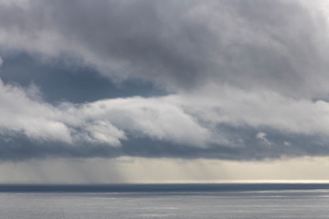 Naklejka na ściany i meble storm and rain clouds coming over the Atlantic Ocean near Faial Fayal Island in the Azores