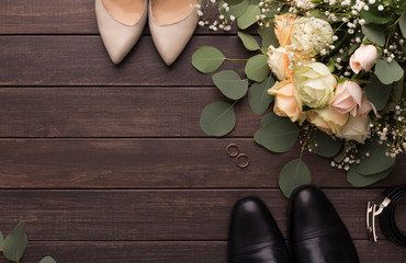 Bride groom shoes and roses bouquet on wooden floor