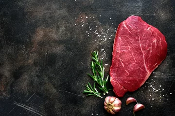 Fotobehang Raw beef steak with spices. Top view with copy space. © lilechka75