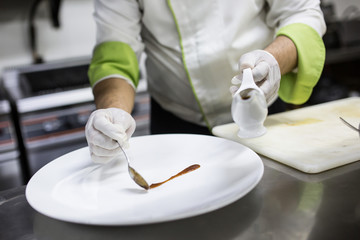 Obraz na płótnie Canvas Chef preparing decoration food dish putting sauce on a white plate