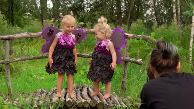 Two wonderful girls pretend to be butterflies for photo shooting. Girls with butterfly wings
