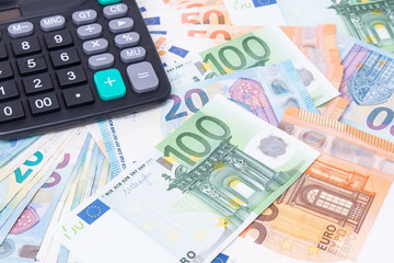 Close-up of calculator on Euro banknotes. Euro money bills to pay. Finances and budget concept. Tax and money.
