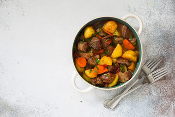 Beef stewed with vegetables on a stone  background