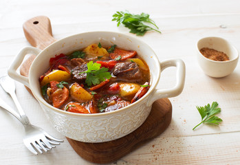 Beef stewed with vegetables on a white wooden background