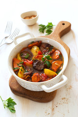 Beef stewed with vegetables on a white wooden background