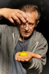 Egg yolk falling from hand to man hand palm