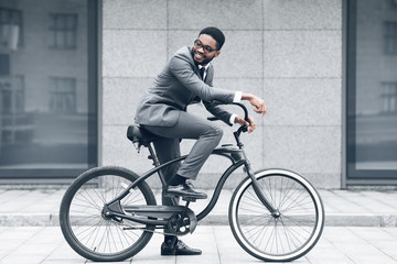 Keep calm and ride on. Businessman cycling against office buiding
