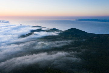 Fototapeta na wymiar Aerial image with magical sunset over a low cloud layer covering Pico Island, with the northcoast and Sao Jorge Island in the background, Azores