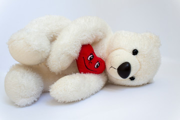 sad miss you lying teddy bear with red love heart on white background