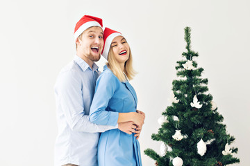 Winter holidays and family concept - Happy young couple near Christmas tree at home