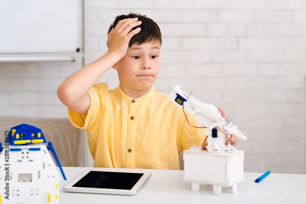 Poster Stem education. Dismayed boy creating robot and made mistake