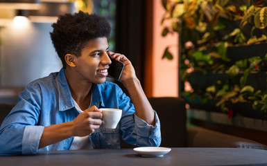 Young afro man talking on mobile phone and smiling