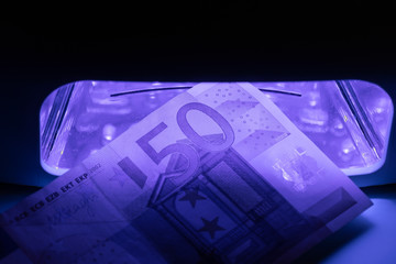 Fifty euro banknote check in infrared light. Real or fake money examination.