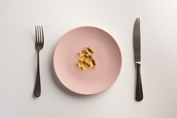 Fish oil capsules on the plate. Flat lay.