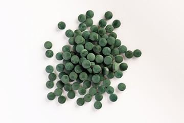 Spirulina tablets on white background. Flat lay.