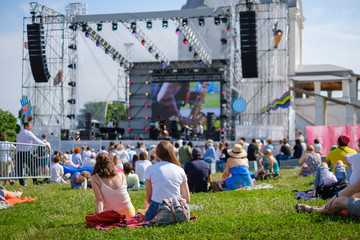 Couple is watching concert at open air music festival - obrazy, fototapety, plakaty