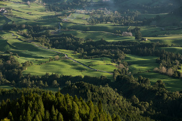Fototapeta premium View on pastures at sunset from near Pico da Vara at Planalto dos Graminhais into the direction of the southeast coast valleys of Nossa Senhora dos Remédios and Povoação