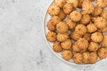 Butter cookies on a white plate on a light table