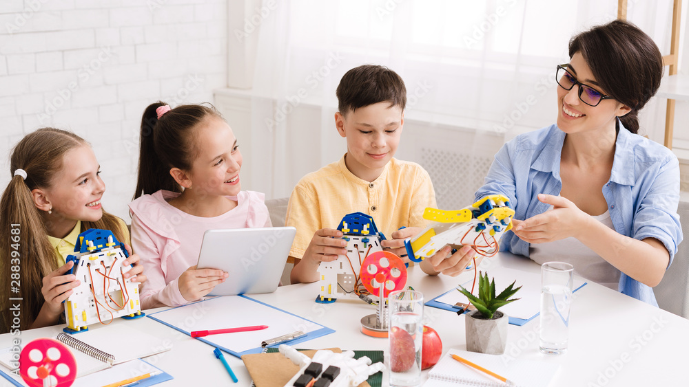 Poster Kids constructing robots with teacher in class