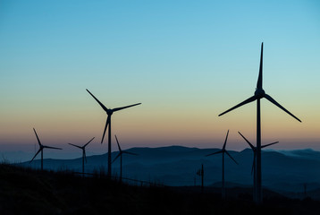 A wind far with wind turbines at Planalto dos Graminhais in a poetic sunset setting, serving as a perfect image for green sustainable renewable engery.