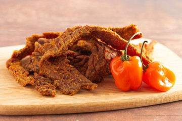 Habanero Pepper Flavored Gourmet Beef Jerky on a Wooden Cutting Board