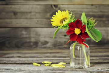 Autumn flowers. Sunflower and dahlia in vase on wooden background
