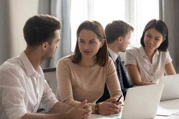 Concentrated employees working at coworking space in international company office.