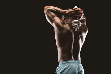 Fototapeta na wymiar Black male fitness model exercising with one dumbbell