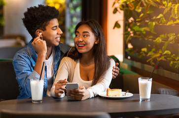 Happy teenagers listening to music on phone