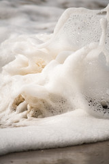 Close-up of Foamy Water Rolling onto Shore