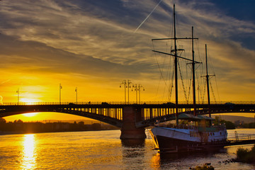 sunset at the Theodor-Heuss Bridge in Mainz-Kastel, Germany with a sailboat