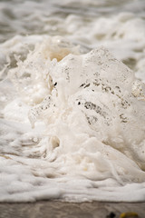 Close-up of Foamy Water Splashing onto Shore
