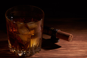 glass of whiskey with cigar on a wooden table