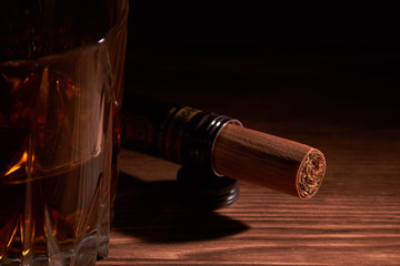 glass of whiskey with cigar on a wooden table