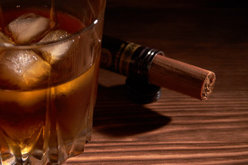 glass of whiskey with cigar on a wooden table