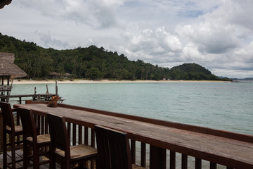 a Wooden bar table and chairs in front of the sea, Koh Talu Island, Thailand