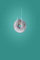 Flying donut with melting glaze against green background