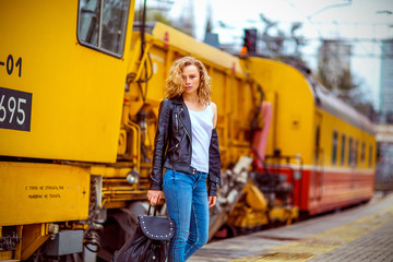 girl with freckles without makeup, near the yellow train at the station