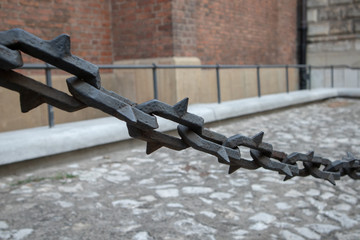 Steel chain with spikes on a wall background